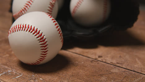 Close-Up-Studio-Baseball-Still-Life-With-Balls-In-Catchers-Mitt-On-Wooden-Floor-4